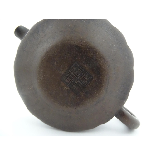 10 - A small Chinese Yixing teapot of lobed form, the lid with bird head finial. Character marks under li... 