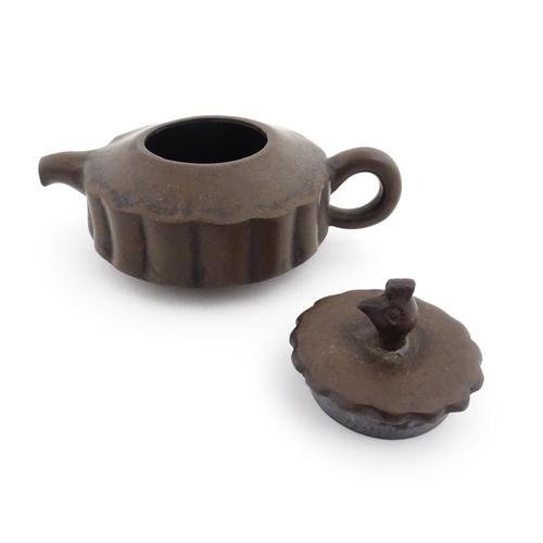 10 - A small Chinese Yixing teapot of lobed form, the lid with bird head finial. Character marks under li... 