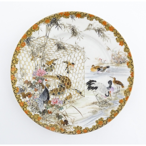 22 - A Japanese Kutani charger / dish decorated with various birds to include ducks, cranes, etc. Charact... 