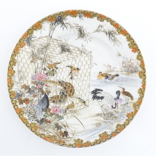 22 - A Japanese Kutani charger / dish decorated with various birds to include ducks, cranes, etc. Charact... 