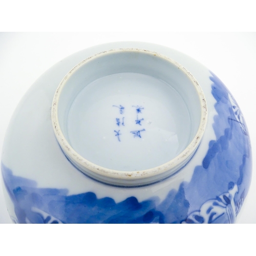 26 - A Chinese blue and white bowl decorated with elder figures in a landscape, the centre with a mountai... 