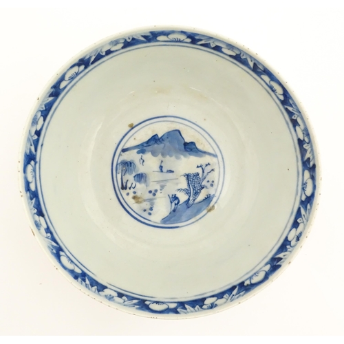 26 - A Chinese blue and white bowl decorated with elder figures in a landscape, the centre with a mountai... 