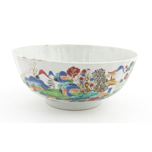 37 - A Chinese famille rose bowl decorated with a mountain landscape scene with pagoda style buildings. A... 