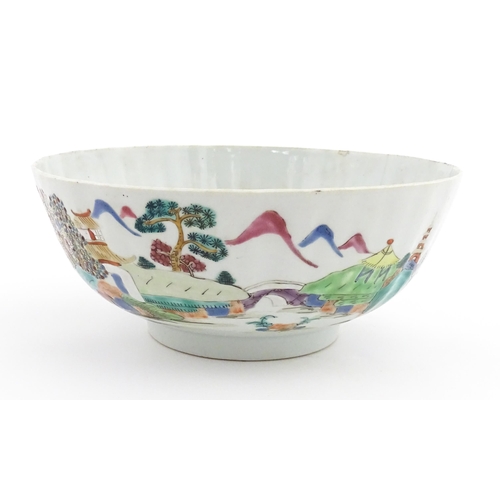 37 - A Chinese famille rose bowl decorated with a mountain landscape scene with pagoda style buildings. A... 