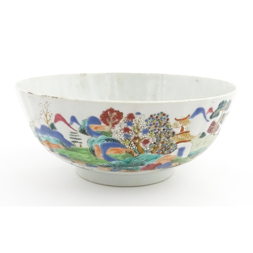 37 - A Chinese famille rose bowl decorated with a mountain landscape scene with pagoda style buildings. A... 