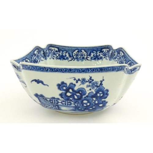 38 - A Chinese blue and white bowl of squared form decorated with flowers, foliage, taihu rock, bats in f... 