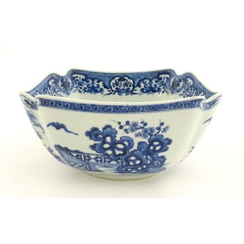 38 - A Chinese blue and white bowl of squared form decorated with flowers, foliage, taihu rock, bats in f... 