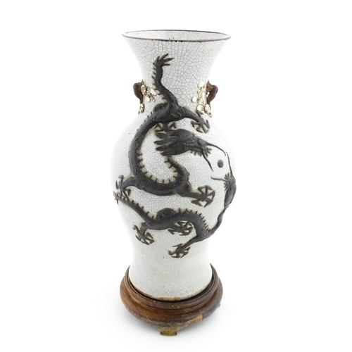 5 - A Chinese crackle glaze vase decorated in relief with dragons chasing the flaming pearl of wisdom. C... 