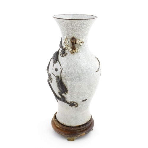 5 - A Chinese crackle glaze vase decorated in relief with dragons chasing the flaming pearl of wisdom. C... 