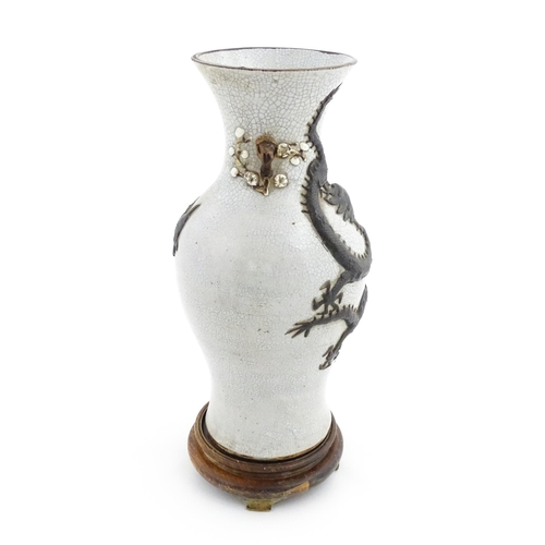 5 - A Chinese crackle glaze vase decorated in relief with dragons chasing the flaming pearl of wisdom. C... 