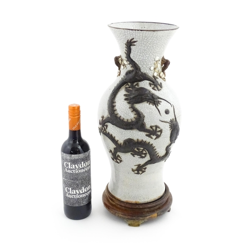 5 - A Chinese crackle glaze vase decorated in relief with dragons chasing the flaming pearl of wisdom. C... 