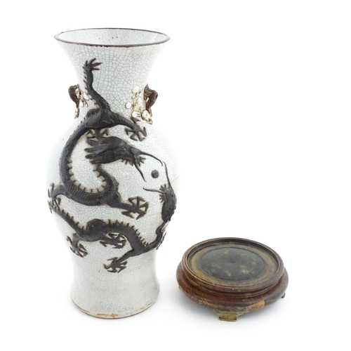 5 - A Chinese crackle glaze vase decorated in relief with dragons chasing the flaming pearl of wisdom. C... 