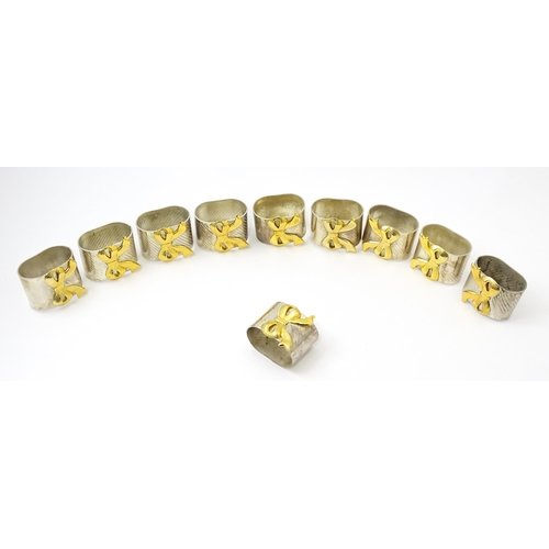 437 - Ten silver plate napkin rings with gilt bow detail.