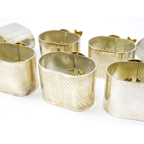 437 - Ten silver plate napkin rings with gilt bow detail.