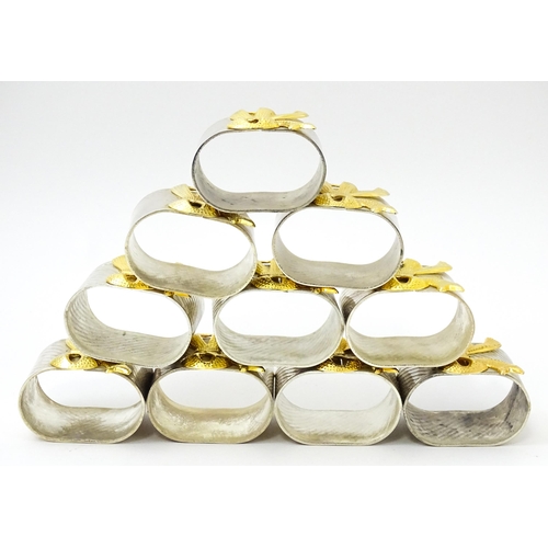 437 - Ten silver plate napkin rings with gilt bow detail.