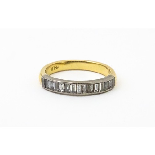 561 - An 18ct gold half eternity ring set with 15 baguette cut diamonds. Ring size approx. M 1/2