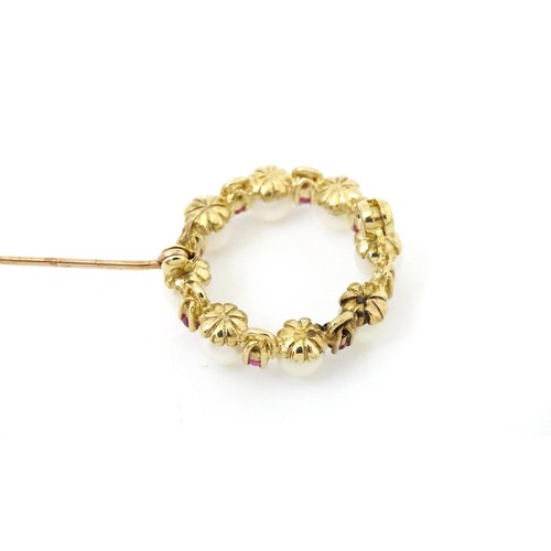 589 - A 9ct gold pendant / brooch of circular set with pearls and round cut rubies. Approx 1