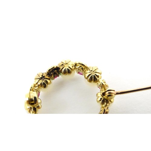 589 - A 9ct gold pendant / brooch of circular set with pearls and round cut rubies. Approx 1