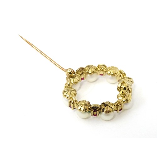 589 - A 9ct gold pendant / brooch of circular set with pearls and round cut rubies. Approx 1