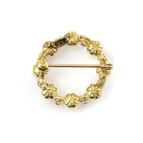 589 - A 9ct gold pendant / brooch of circular set with pearls and round cut rubies. Approx 1
