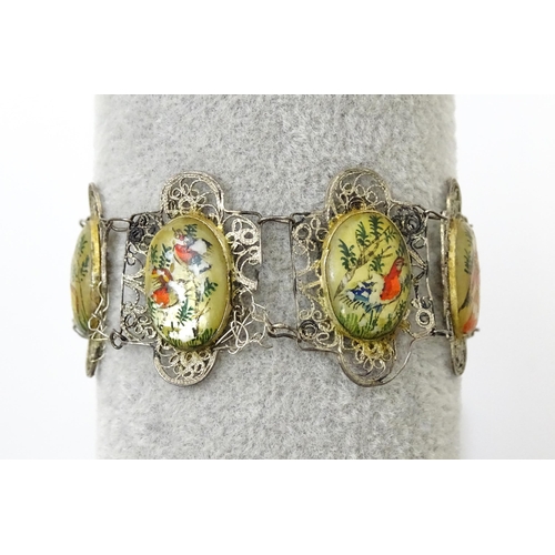 717 - An Indian white metal bracelet with hand painted mother of pearl panels. Approx. 7 1/2