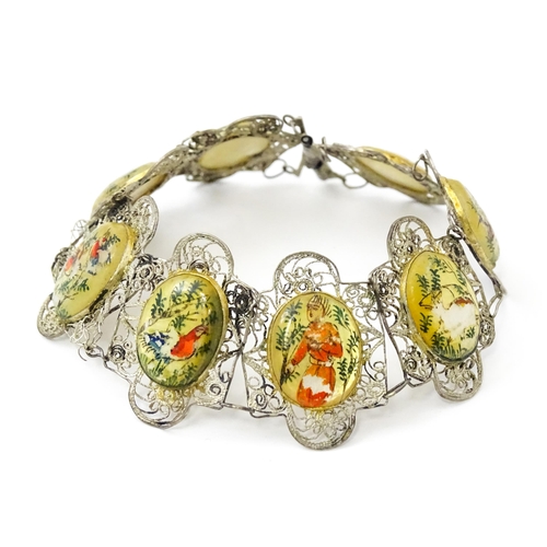 717 - An Indian white metal bracelet with hand painted mother of pearl panels. Approx. 7 1/2