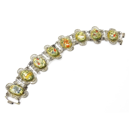 717 - An Indian white metal bracelet with hand painted mother of pearl panels. Approx. 7 1/2