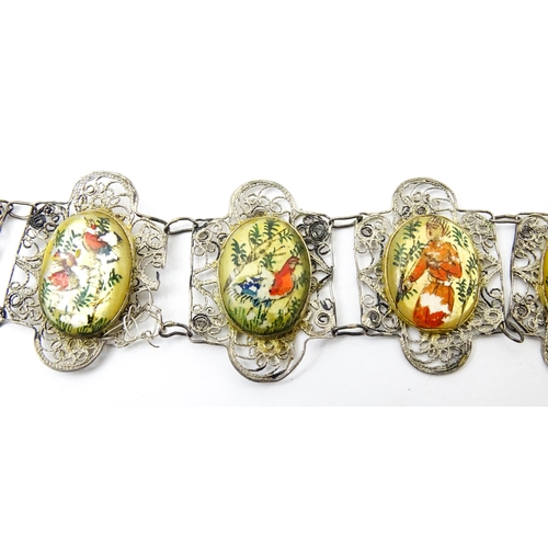 717 - An Indian white metal bracelet with hand painted mother of pearl panels. Approx. 7 1/2