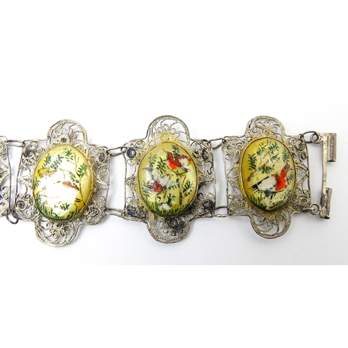 717 - An Indian white metal bracelet with hand painted mother of pearl panels. Approx. 7 1/2