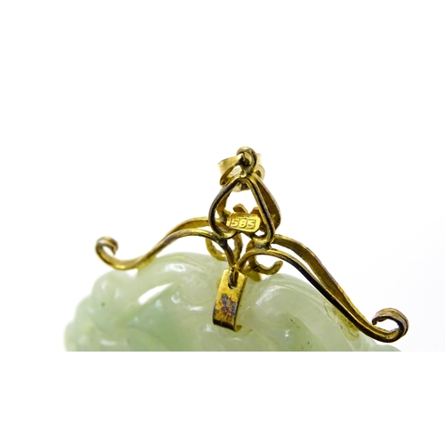 740 - An Oriental carved jade pendant with yellow metal mounts marked 585. Approx. 2 3/4