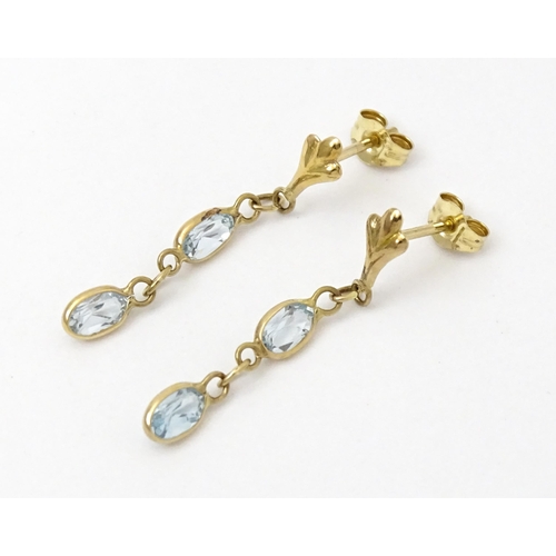 763 - A pair of yellow metal drop earrings set with aquamarine. Approx. 1