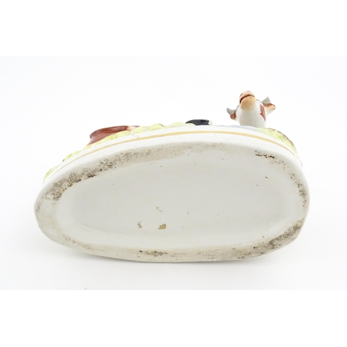 44 - A Staffordshire pottery model of a cow and calf on a naturalistic base. Approx. 7