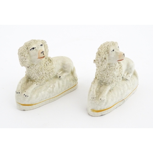 48 - Five assorted pottery models of dogs to include two Staffordshire pottery seated poodles, a seated s... 