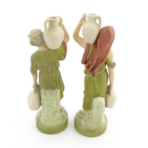 55 - A pair of Royal Dux classical water carrier figures depicting a male and female carrying water vases... 