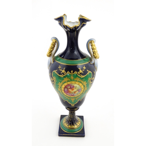 59 - A Coalport style cabinet vase with twin handles and shaped rim, decorated with a hand painted vignet... 