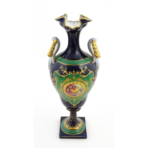 59 - A Coalport style cabinet vase with twin handles and shaped rim, decorated with a hand painted vignet... 