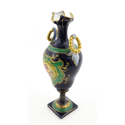 59 - A Coalport style cabinet vase with twin handles and shaped rim, decorated with a hand painted vignet... 