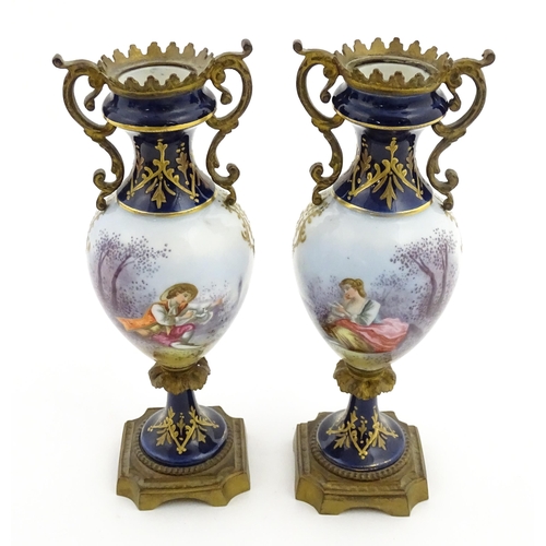 61 - A pair of Sevres style vases with cobalt blue ground and gilt metal mounts, each decorated with a yo... 