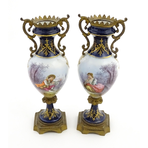 61 - A pair of Sevres style vases with cobalt blue ground and gilt metal mounts, each decorated with a yo... 