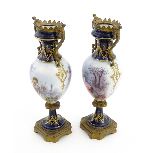 61 - A pair of Sevres style vases with cobalt blue ground and gilt metal mounts, each decorated with a yo... 