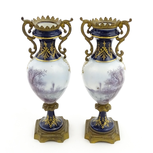 61 - A pair of Sevres style vases with cobalt blue ground and gilt metal mounts, each decorated with a yo... 