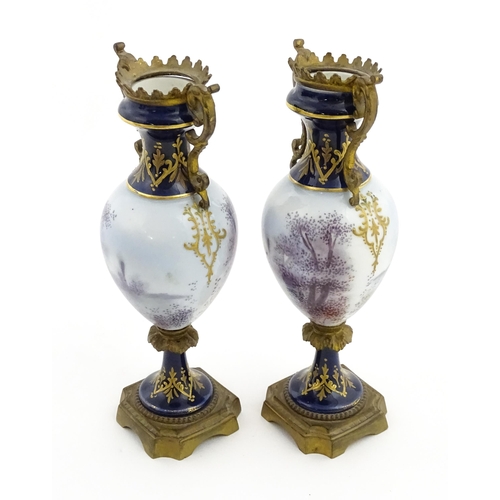 61 - A pair of Sevres style vases with cobalt blue ground and gilt metal mounts, each decorated with a yo... 