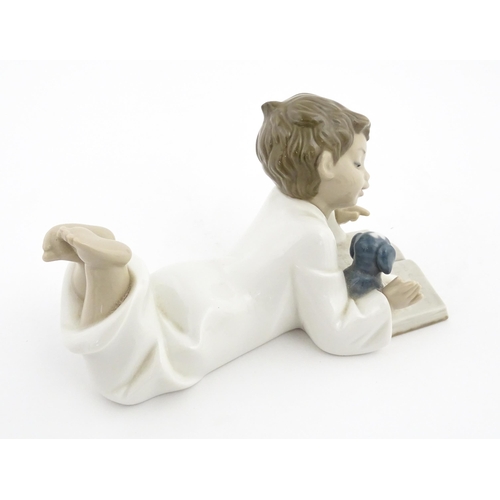 76 - A Nao figure Repeat After Me, modelled as a young boy reading with a puppy. Marked under. Approx. 4