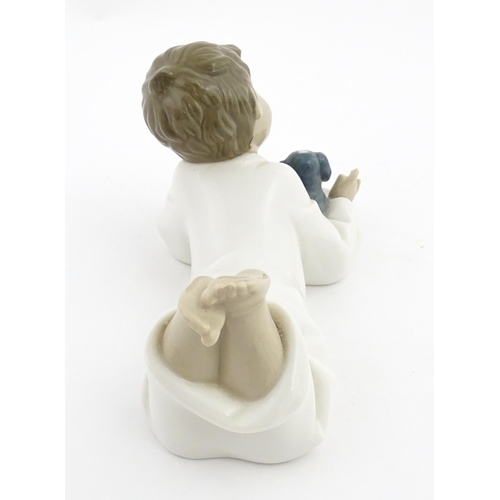 76 - A Nao figure Repeat After Me, modelled as a young boy reading with a puppy. Marked under. Approx. 4