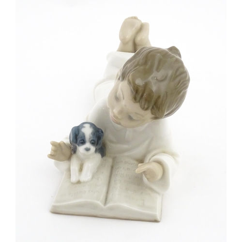 76 - A Nao figure Repeat After Me, modelled as a young boy reading with a puppy. Marked under. Approx. 4