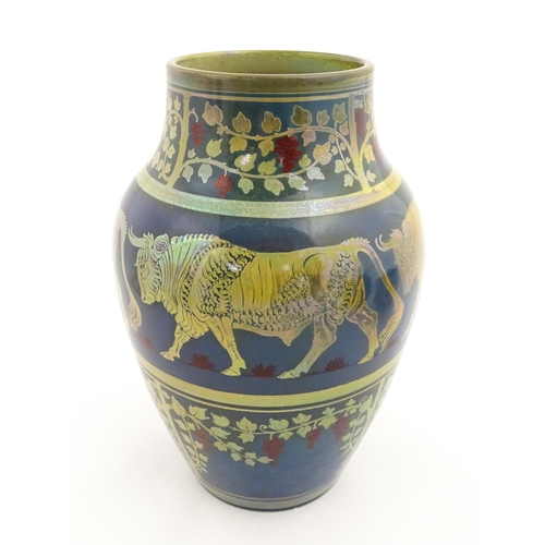 A Pilkington's Royal Lancastrian lustre vase with banded decoration depicting bulls and fruiting vine. Designed by Richard Joyce. Marked under and numbered 2085. Approx. 10 1/4" high