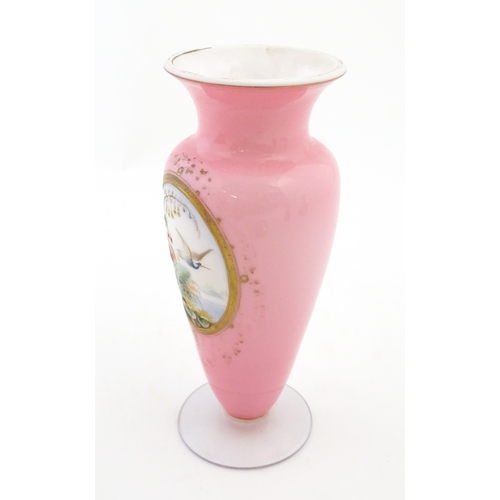 184 - A 19thC pink opaline glass vase with hand painted oval depicting floral and foliate scene with crane... 