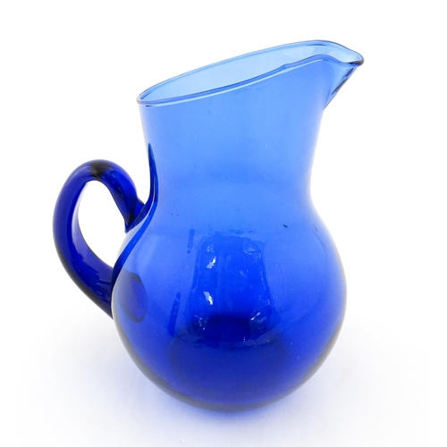 190 - A blue glass water jug with loop handle. Approx. 9