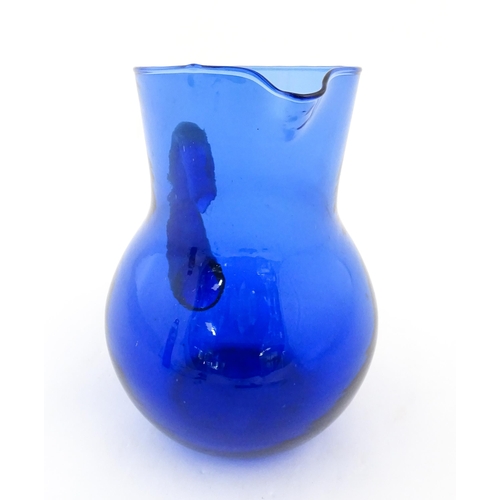 190 - A blue glass water jug with loop handle. Approx. 9