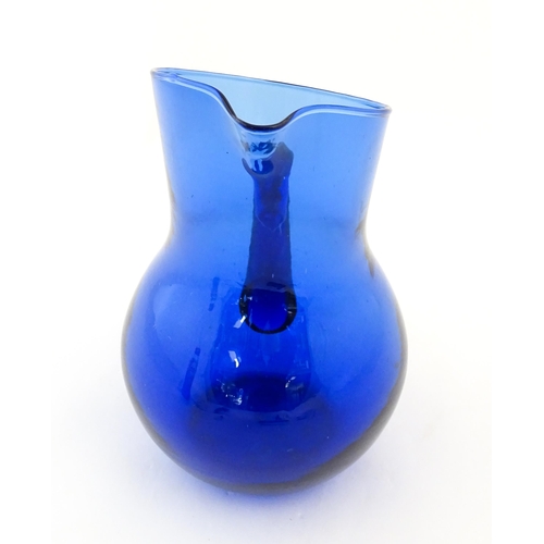 190 - A blue glass water jug with loop handle. Approx. 9